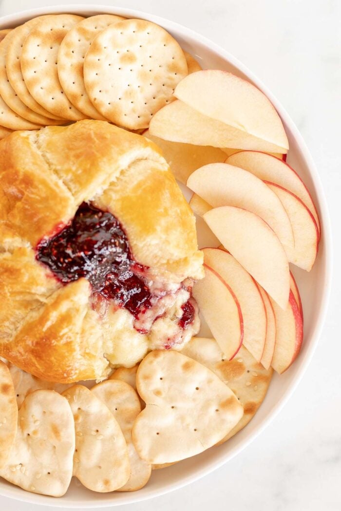 baked brie in puff pastry surrounded by fruit and crackers