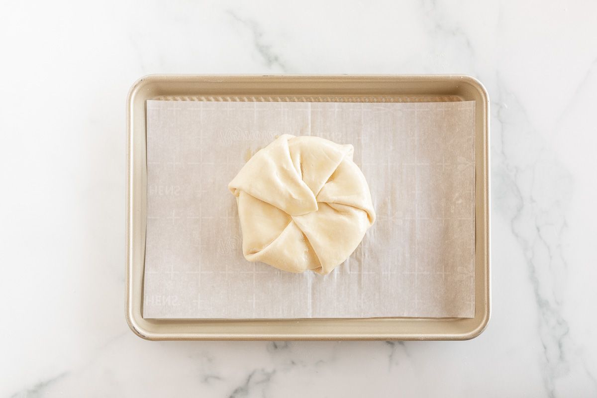 baked brie puff pastry round on a gold baking sheet