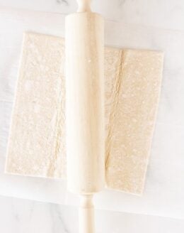 puff pastry on a marble surface with rolling pin