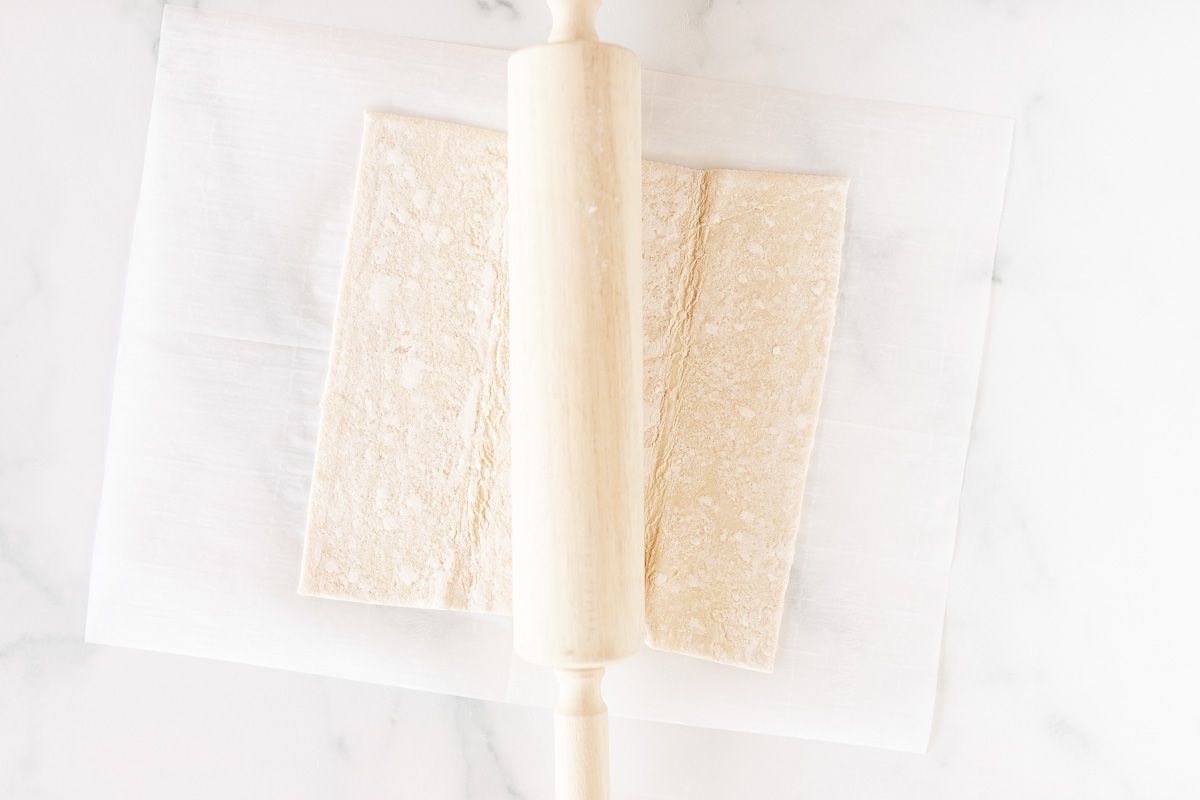 puff pastry on a marble surface with rolling pin
