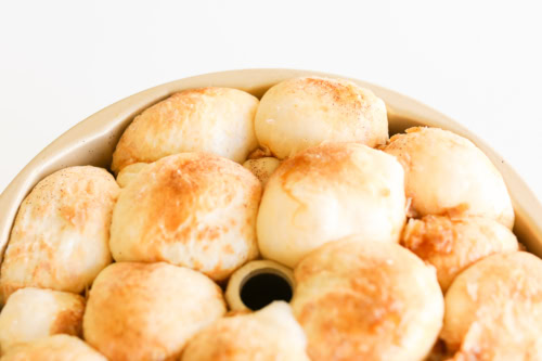 A tray of freshly baked golden brown dinner rolls, resembling the delightful texture of monkey bread, close-up view.