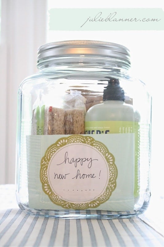 A glass jar filled with kitchen supplies and a housewarming tag