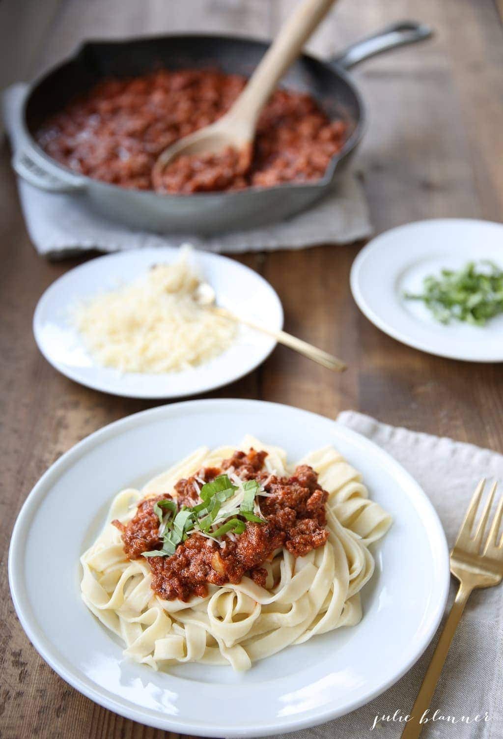 Pasta and sauce served on a white plate with a fork