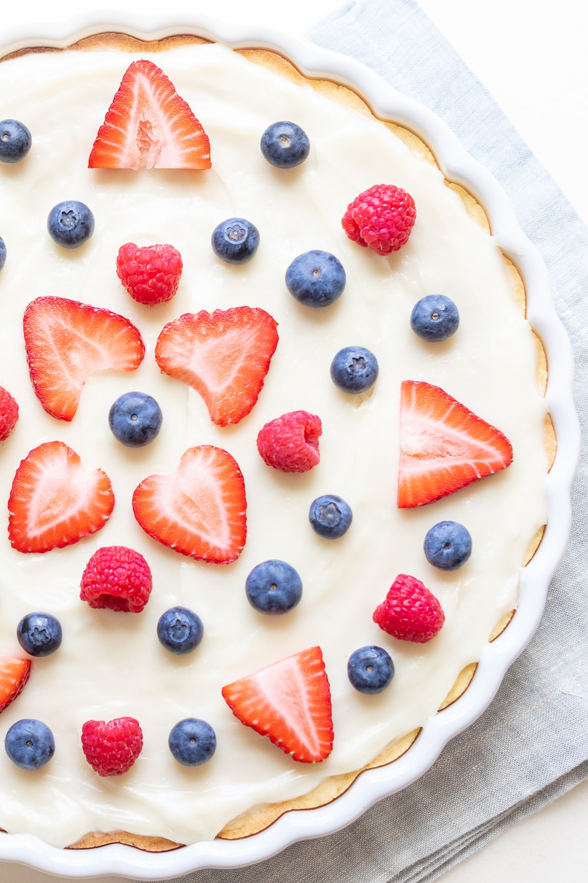 A close up of a fruit pizza with cream cheese fruit pizza icing on top.