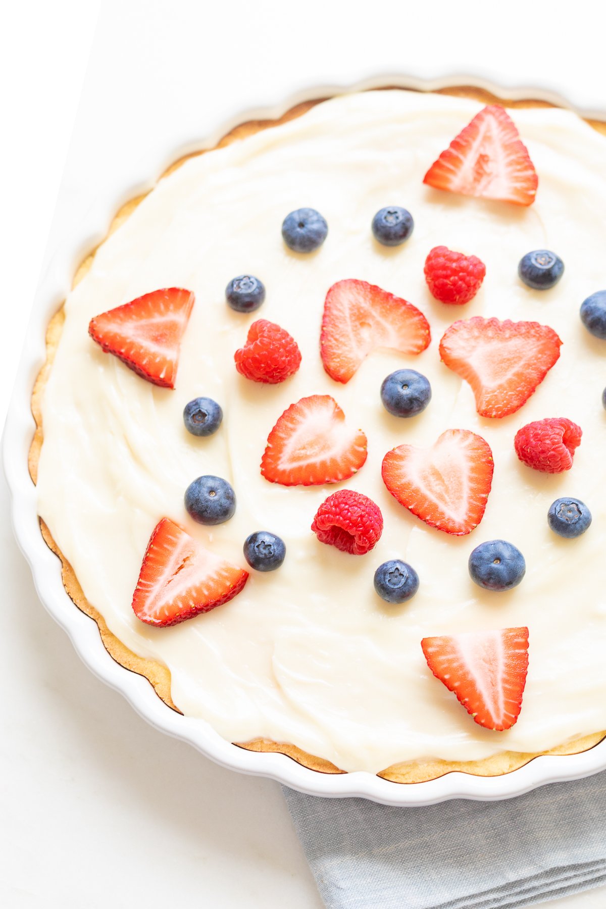 A close up of a fruit pizza with cream cheese fruit pizza icing on top.