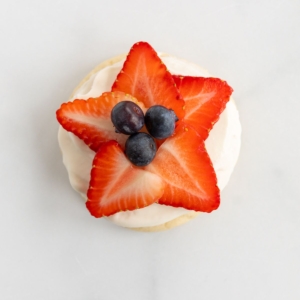 A fruit pizza cookie with strawberries and blueberries on top in the shape of a star