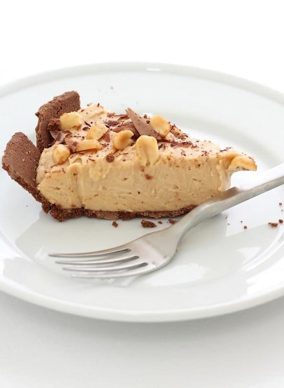 A slice of no bake peanut butter cheesecake on a white plate