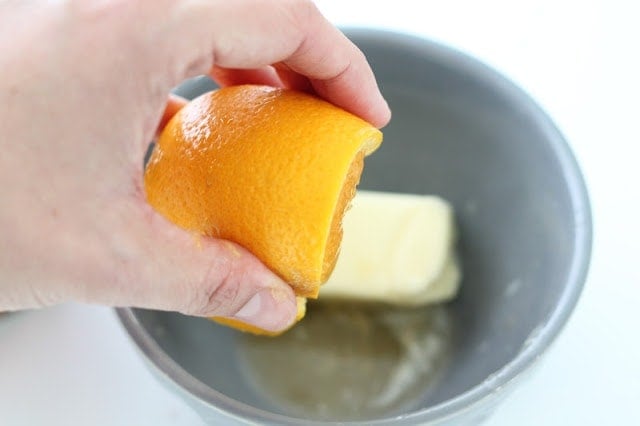 squeezing orange over butter in a bowl