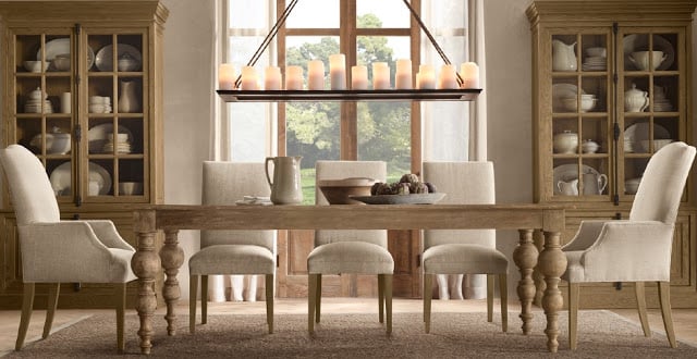 wood table with linen chairs and candle chandelier overhead