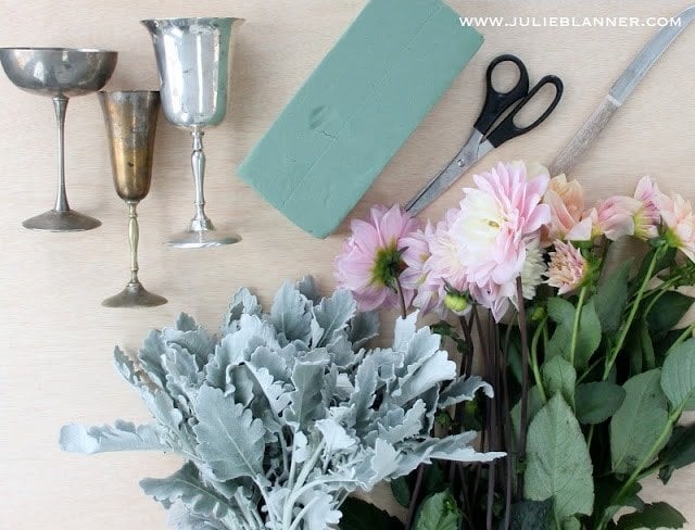 ingredients for a DIY flower arrangement laid out on a wood surface