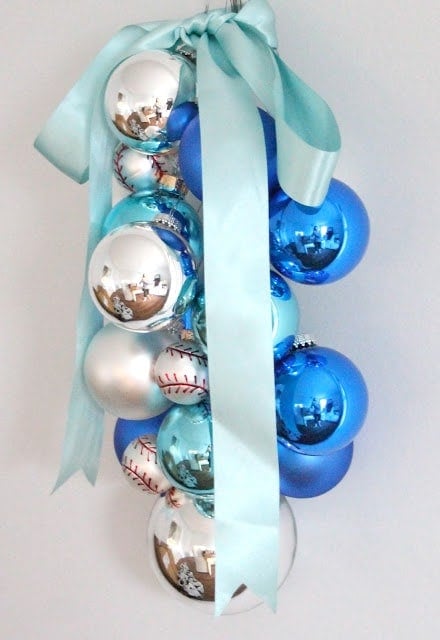 Blue, silver, and baseball ornaments hanging with a blue ribbon