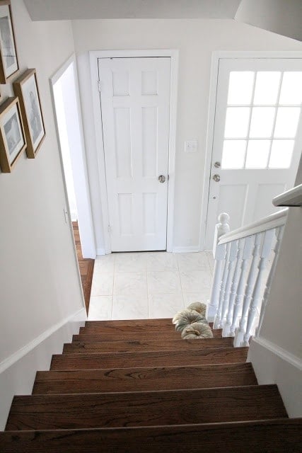 White stairs with wooden tops and white hand railings.