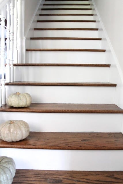 White stairs with wooden tops and white hand railings.