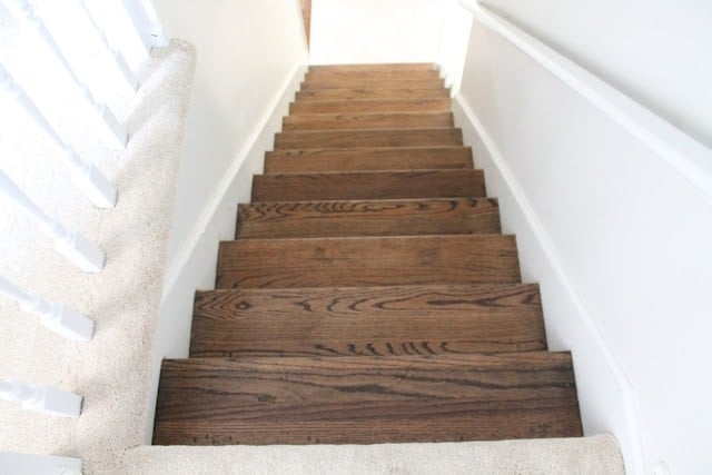 White stairs with wooden tops and white hand railings.