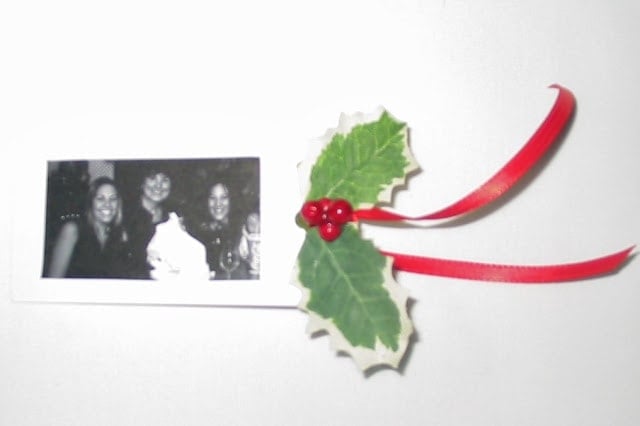 A photo embellishment for Christmas gift wrap with a red ribbon.