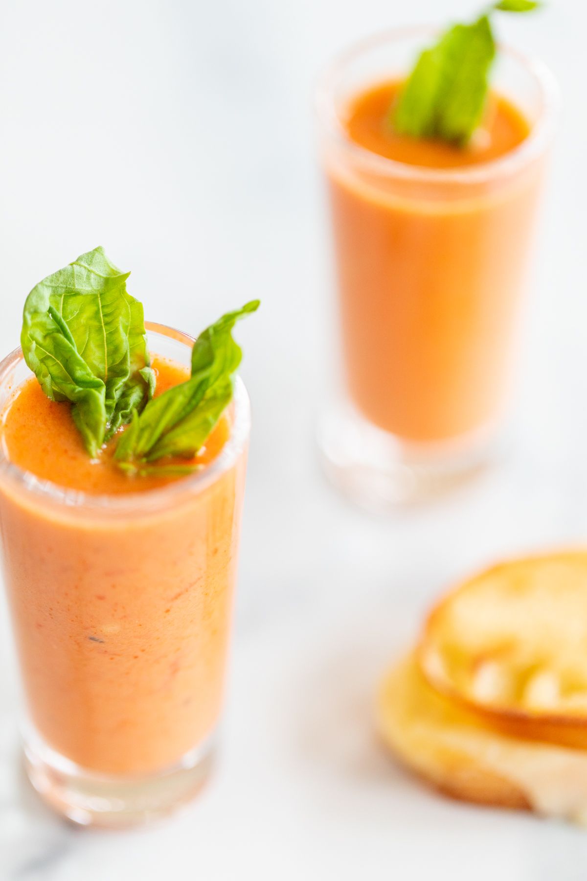 Small glass shooters of creamy tomato soup.