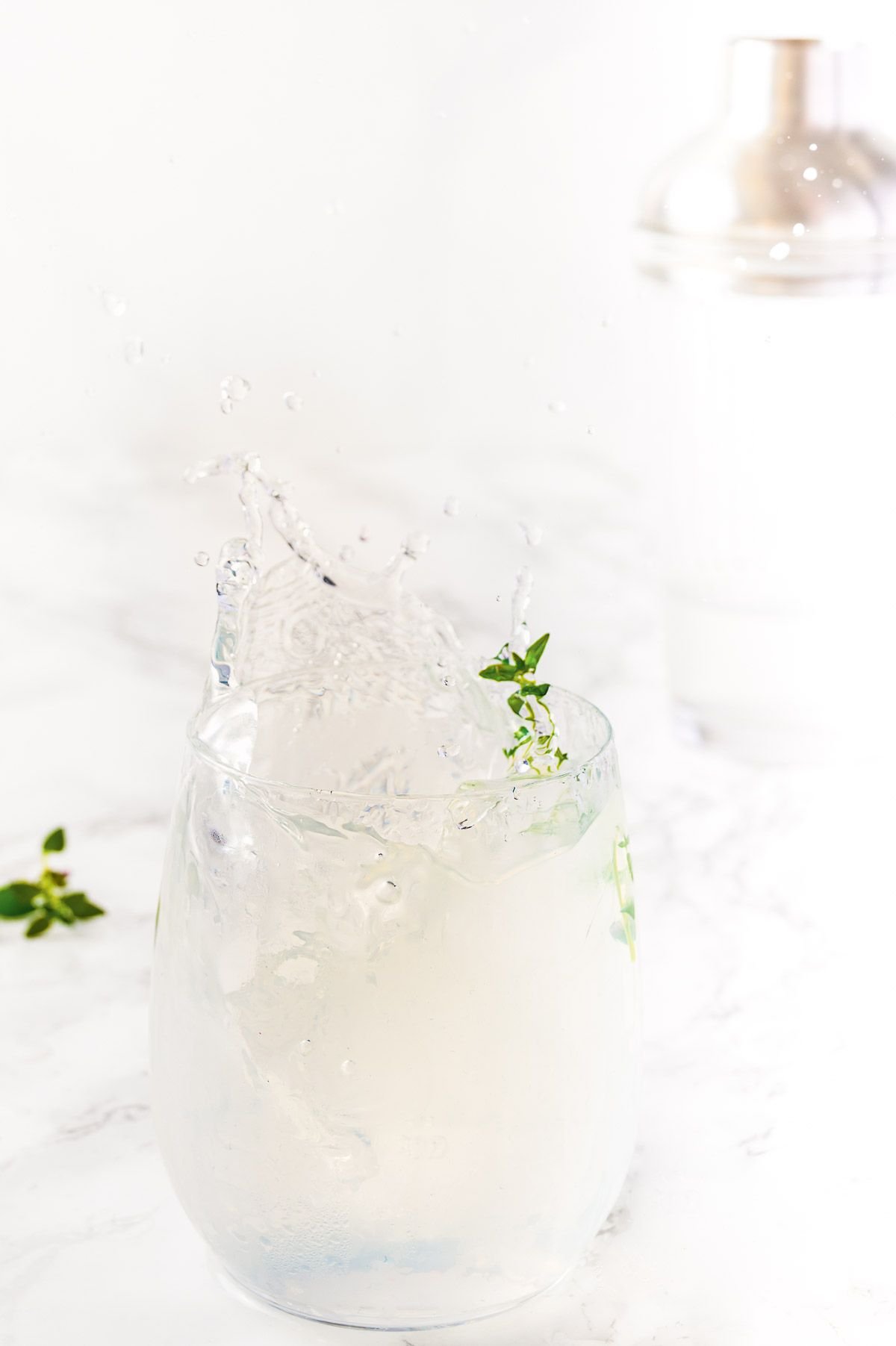 A cocktail with lemonade and vodka on a white surface.