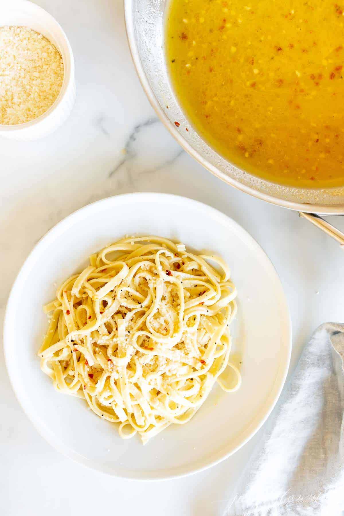 white wine sauce in saucepan by bed of pasta