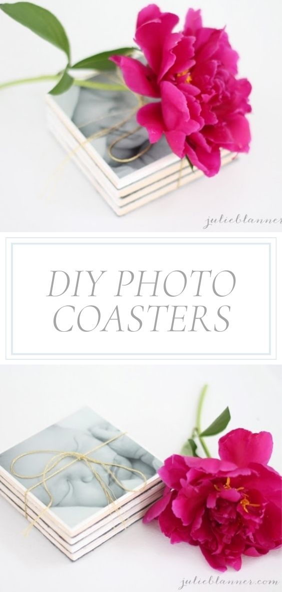 On a marble counter, there is a photo coaster next to a pink flower.