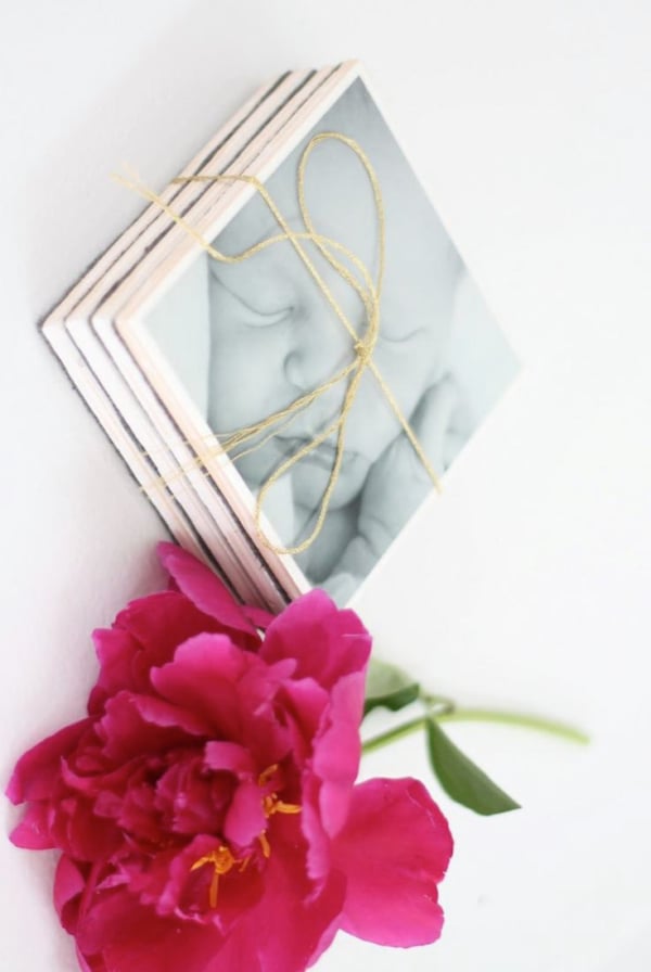 DIY photo coasters featuring a baby picture, topped with a peony.