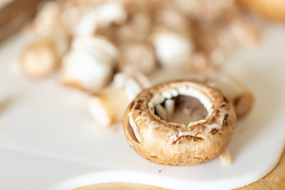 Fresh mushrooms sliced on a white cutting board.