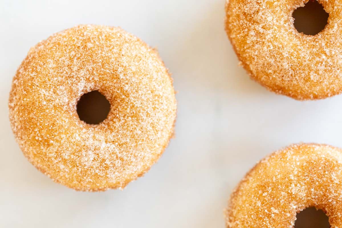 Cinnamon sugar donuts on a marble countertop.