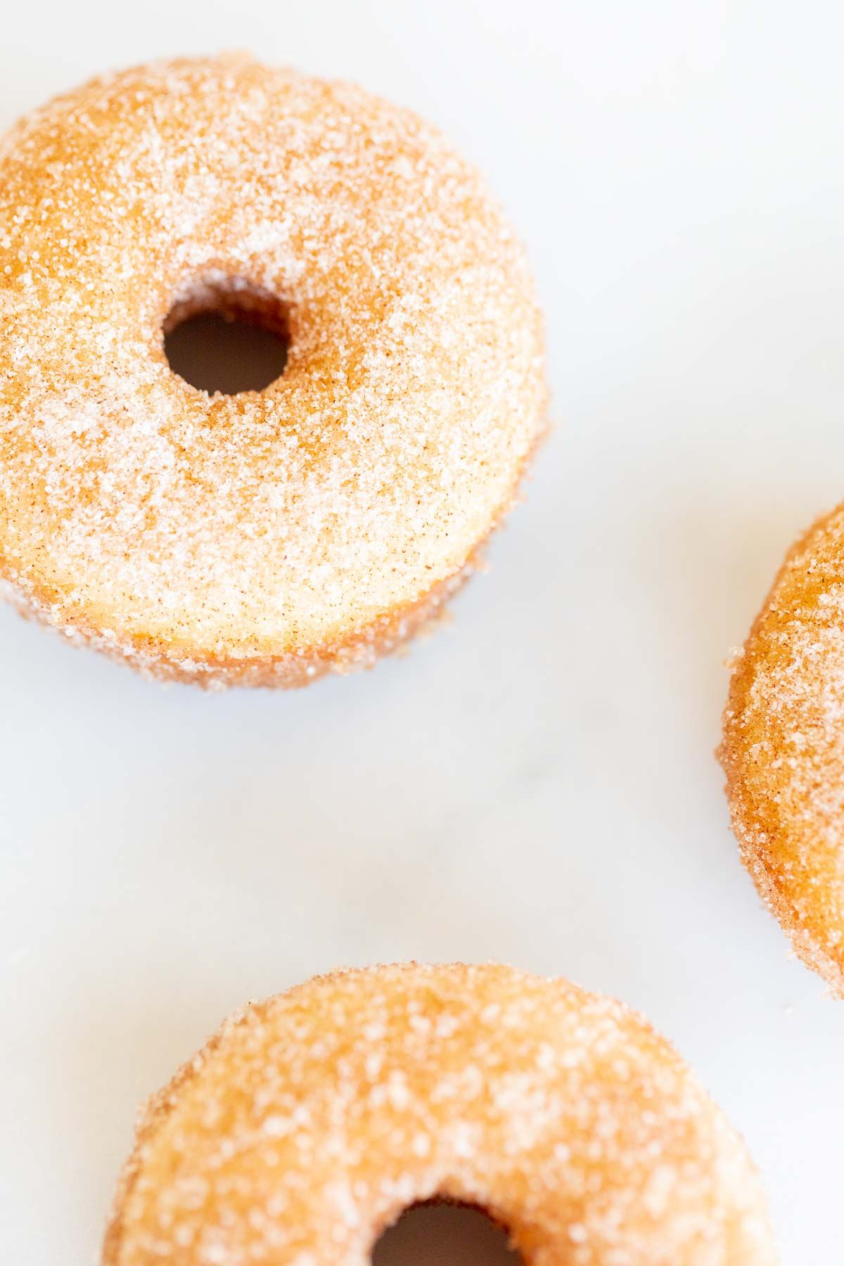 Cinnamon sugar donuts on a marble countertop.