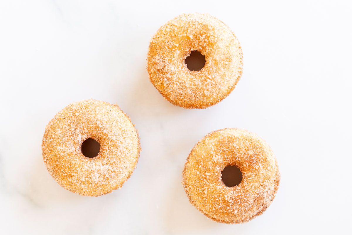 Cinnamon sugar donuts on a marble countertop.