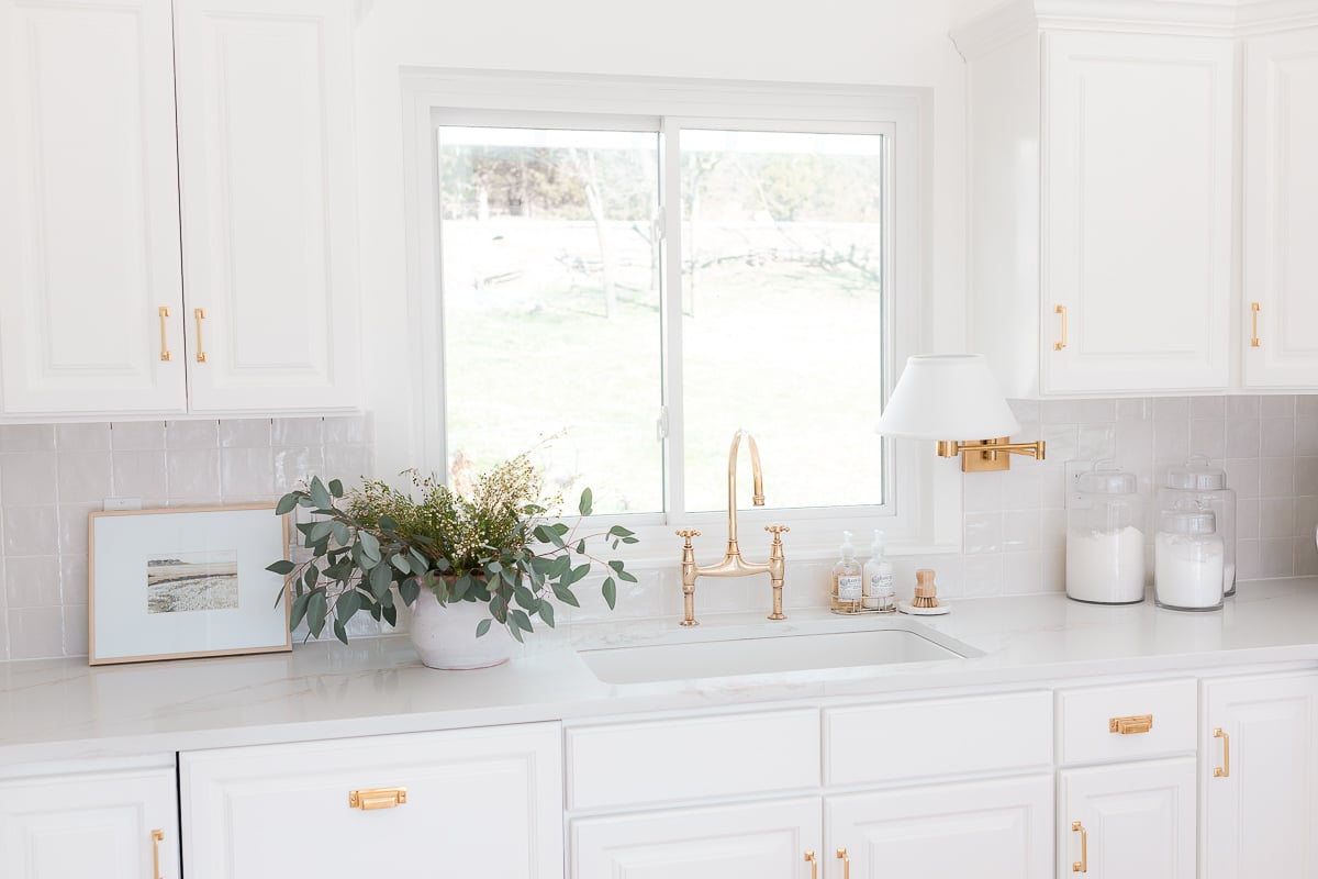 A white kitchen with white quartz countertops in a guide to carrara marble countertop alternatives.