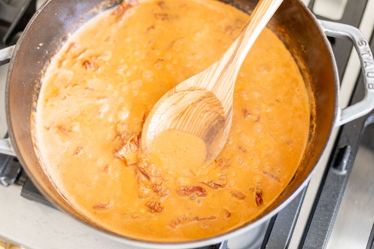 Sun dried tomato chicken pasta sauce in a pan on stovetop.