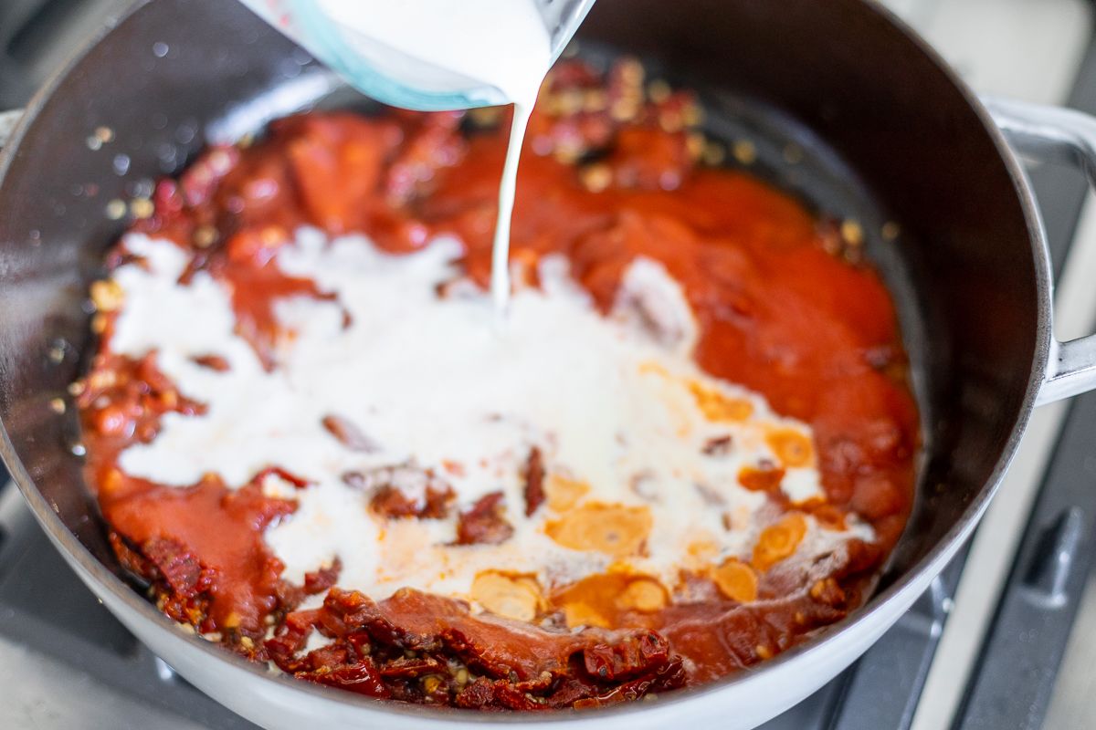 Sun dried tomato chicken pasta sauce in a pan on stovetop.