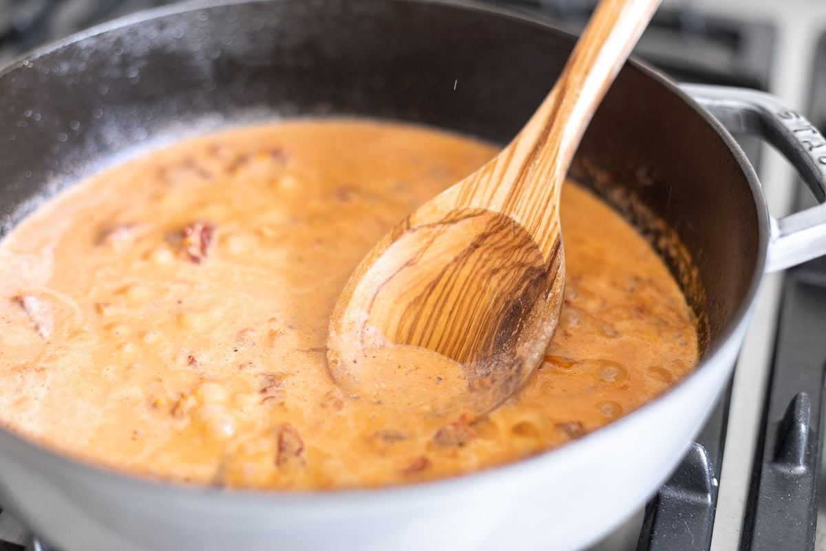 Sun dried tomato chicken pasta sauce in a pan on stovetop.