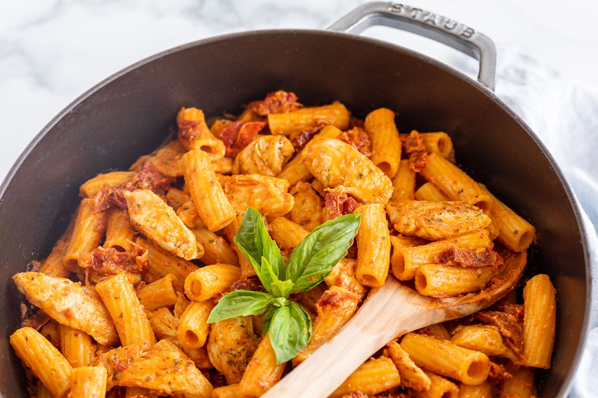 Sun dried tomato chicken pasta in a cast iron skillet.