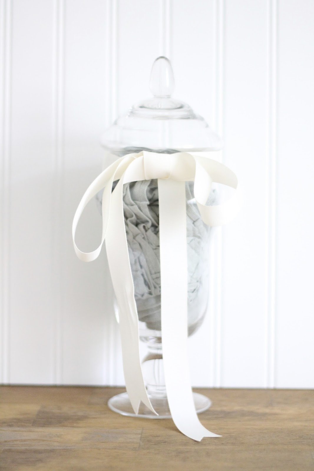 An apothecary jar with ruffled linen napkins inside for a housewarming gift