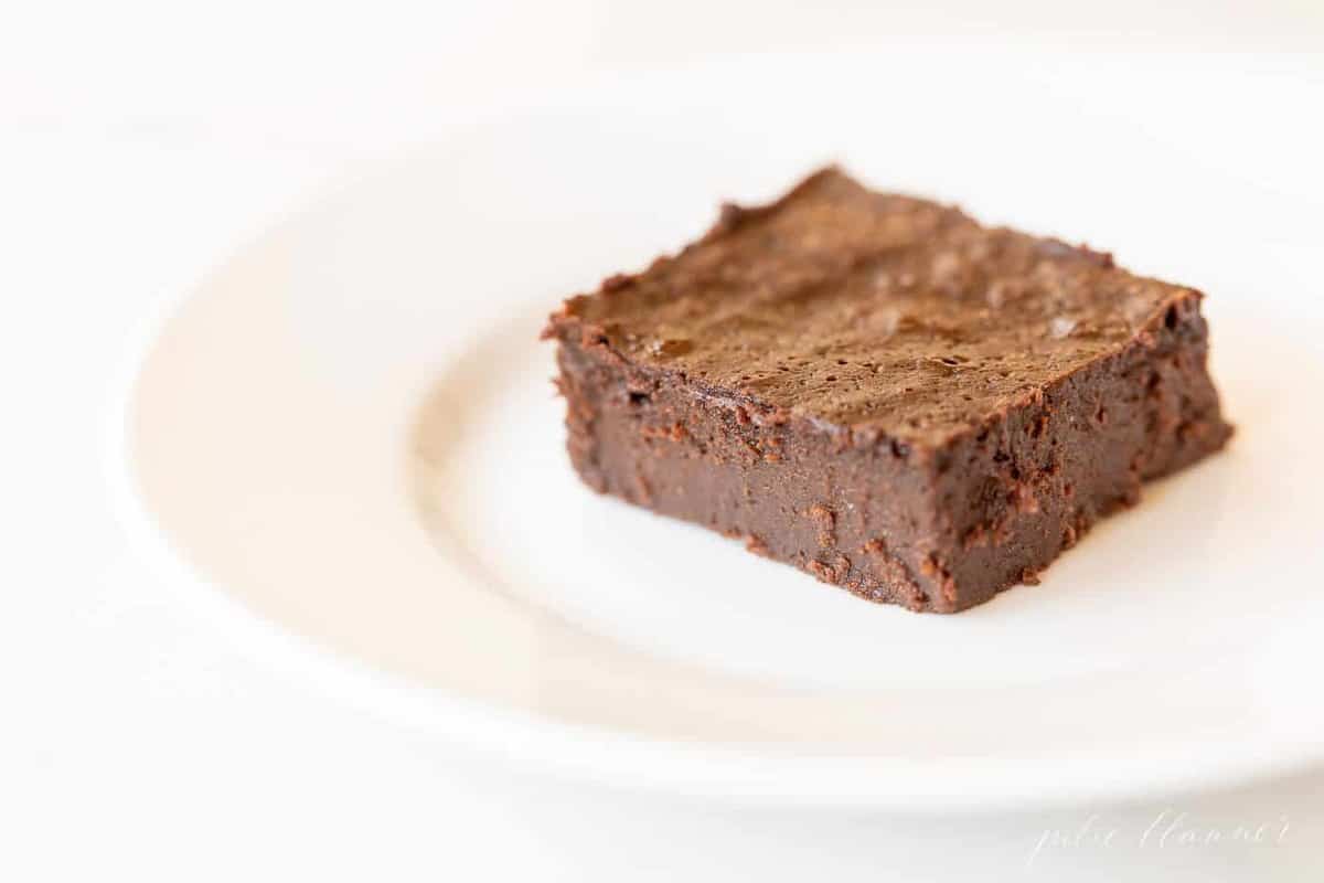 White plate with a slice of flourless brownies. 