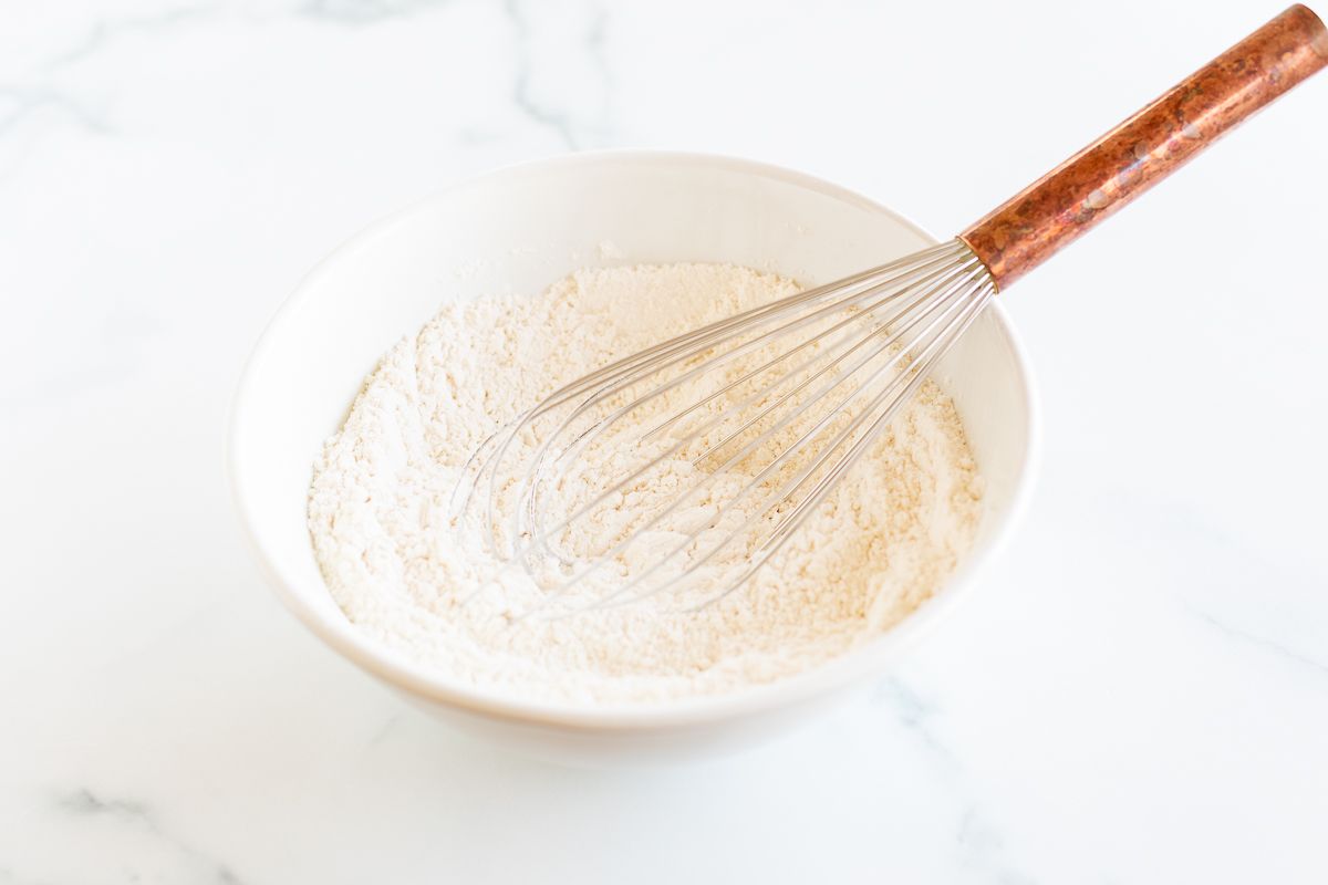 Dry ingredients for cookie dough in a white bowl.