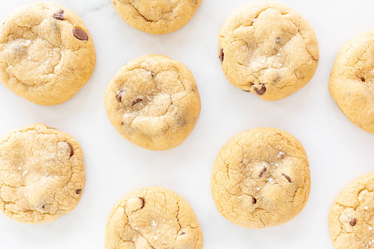 Salted caramel chocolate chip cookies on a parchment lined baking sheet.