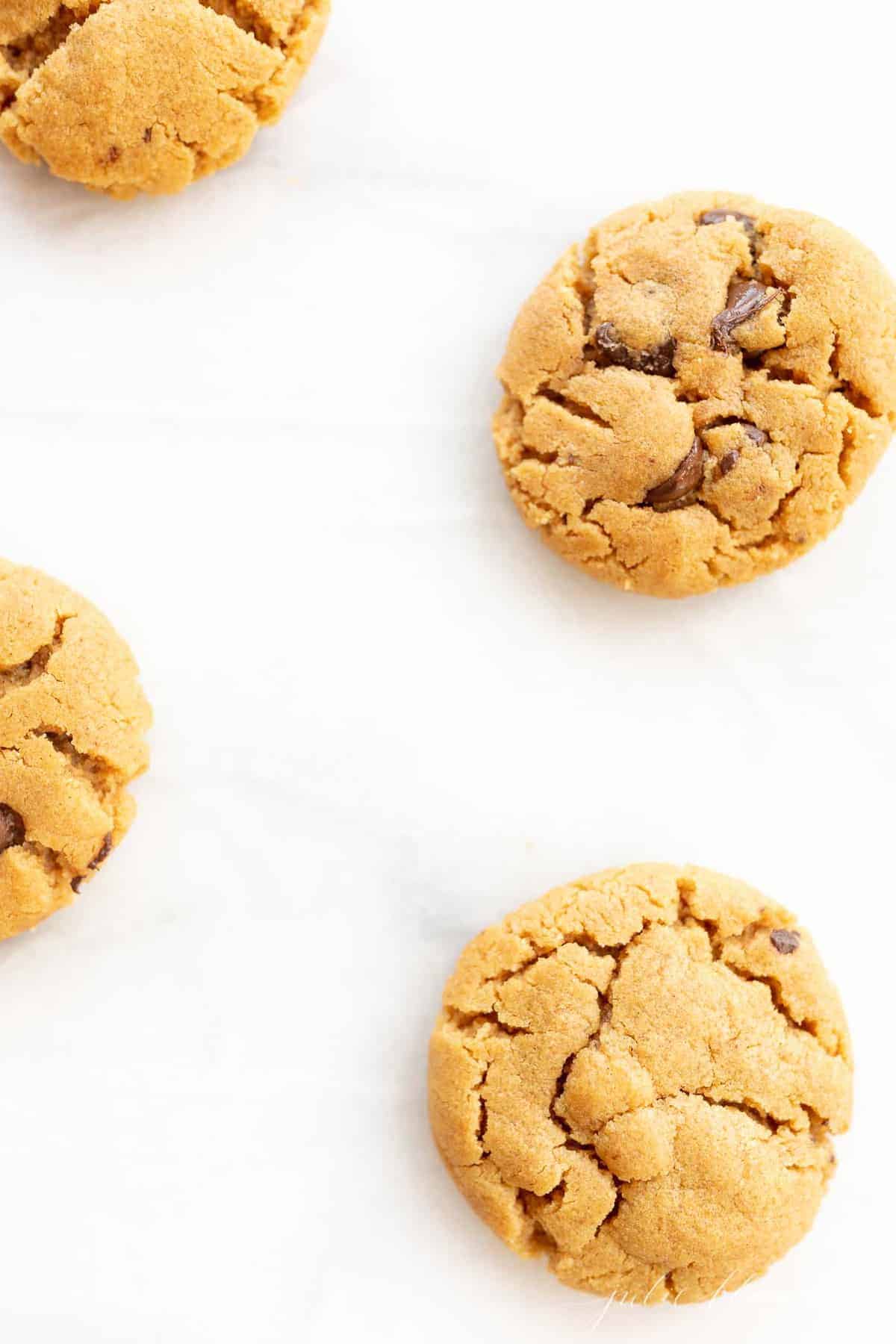 gluten free peanut butter chocolate chip cookies scattered on marble counter