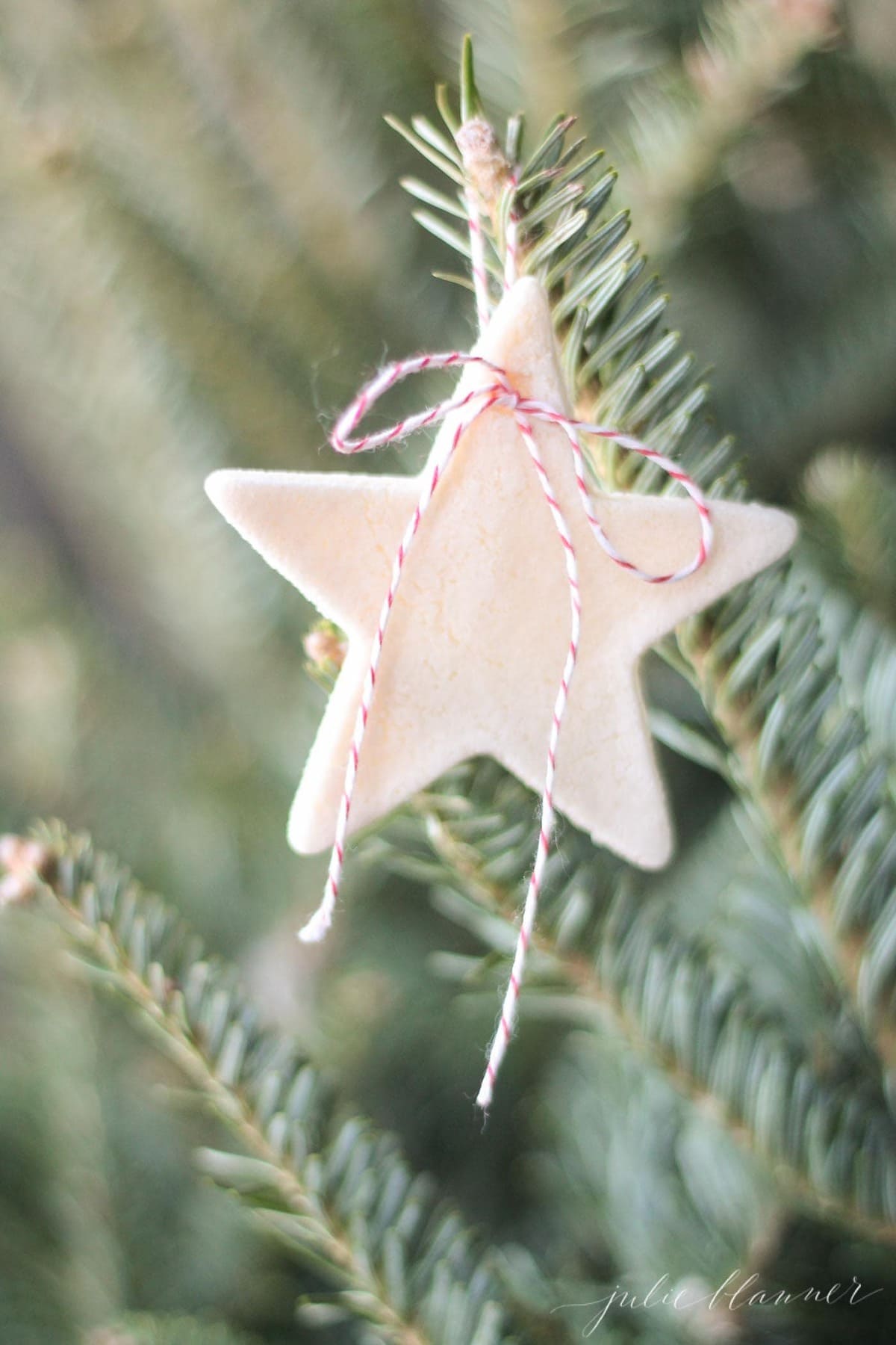 Salt dough ornaments shaped into a star hanging from a Christmas Tree. 