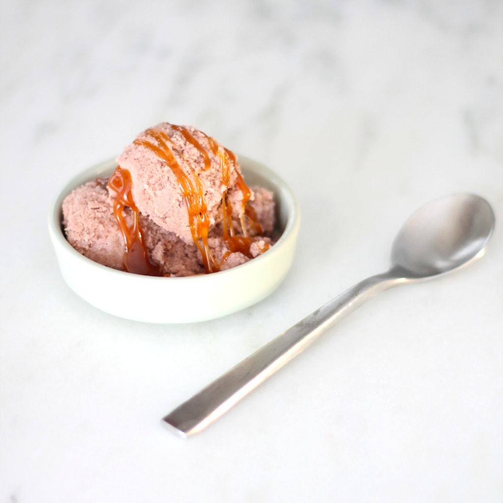 chocolate snow ice cream with caramel sauce on top in a small dish