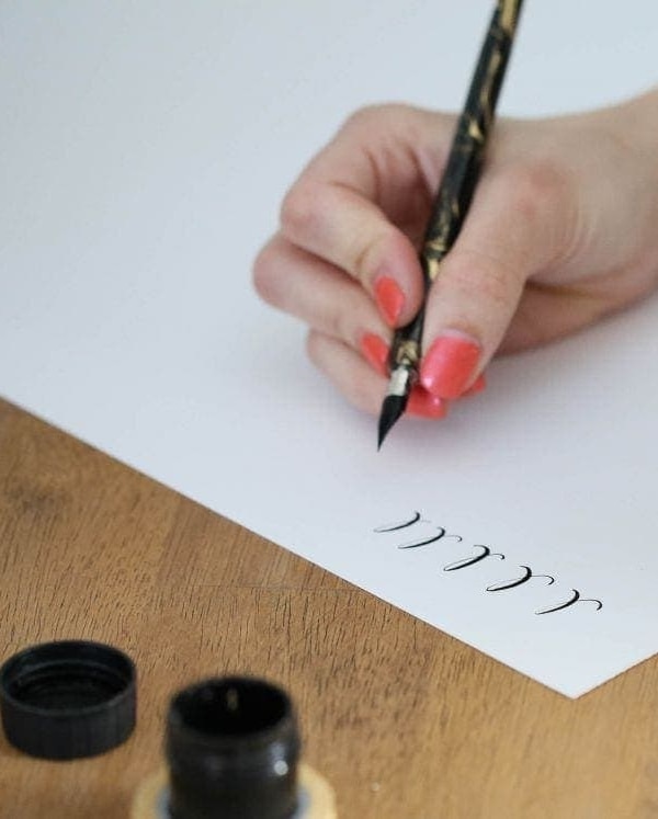 A woman practicing the calligraphy alphabet.