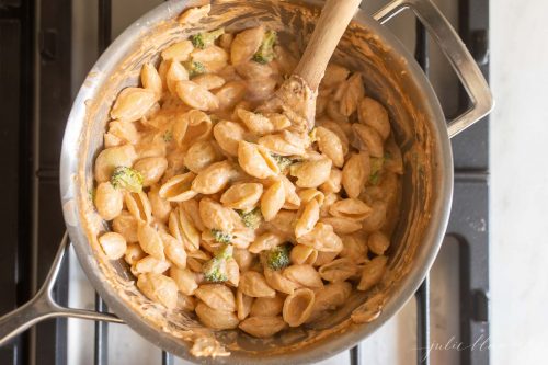 stirring parmesan into pasta con broccoli