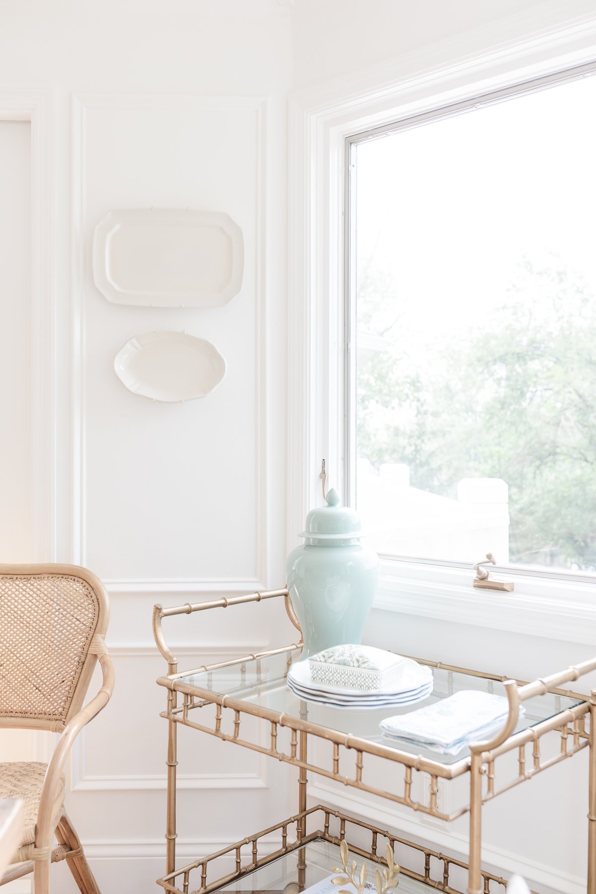 A white dining room with wall plates on the white walls