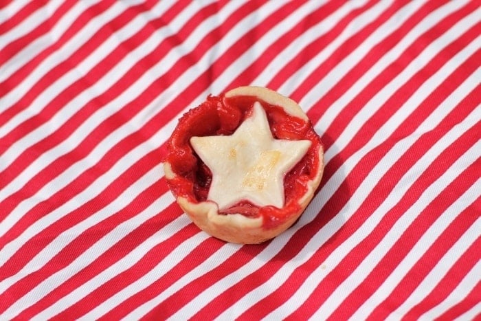 A strawberry pie on a red an white cloth