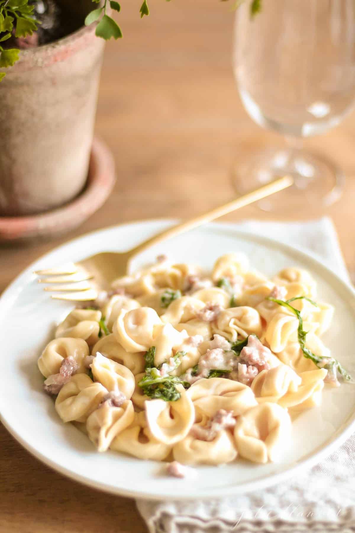 maggianos tortellacci on white plate next to plant