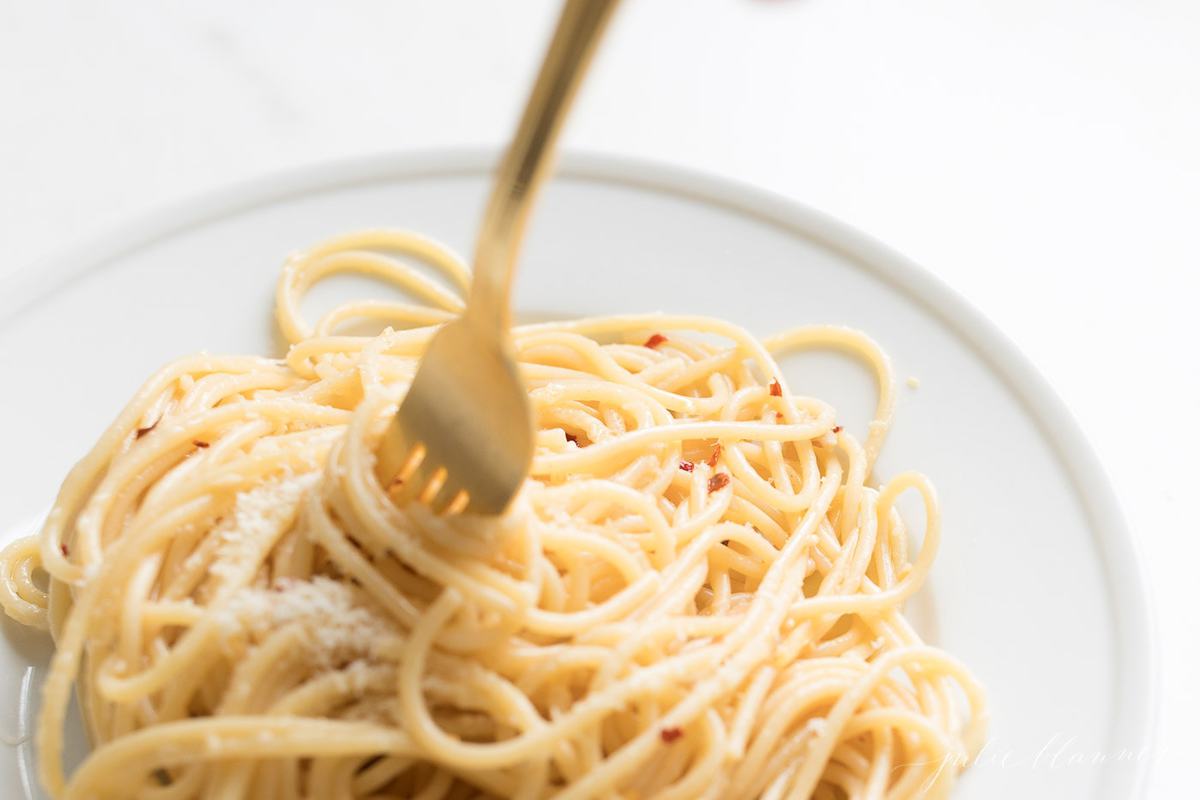 gold for twirling pasta on white plate