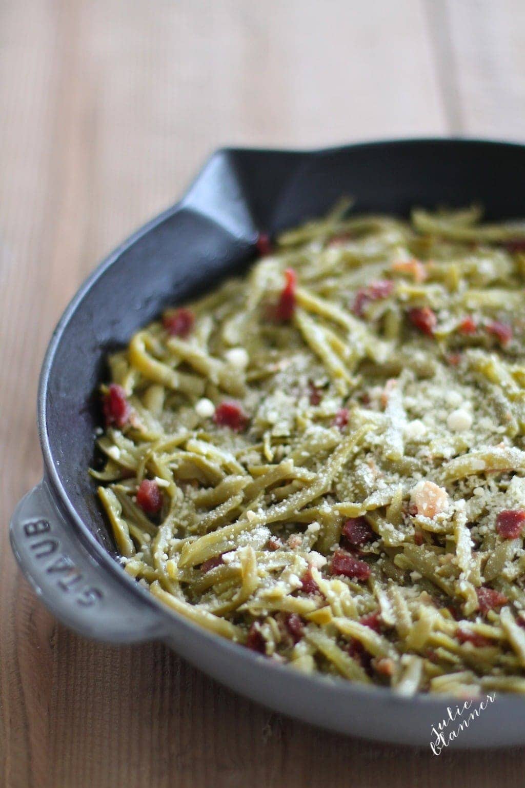 Easy green beans with bacon topped with parmesan in a skillet