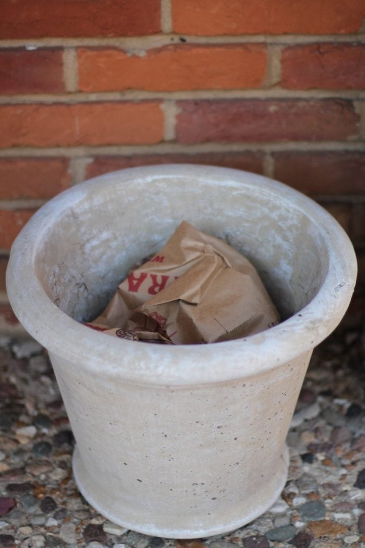 A porch planter with paper grocery bags inside for filler.