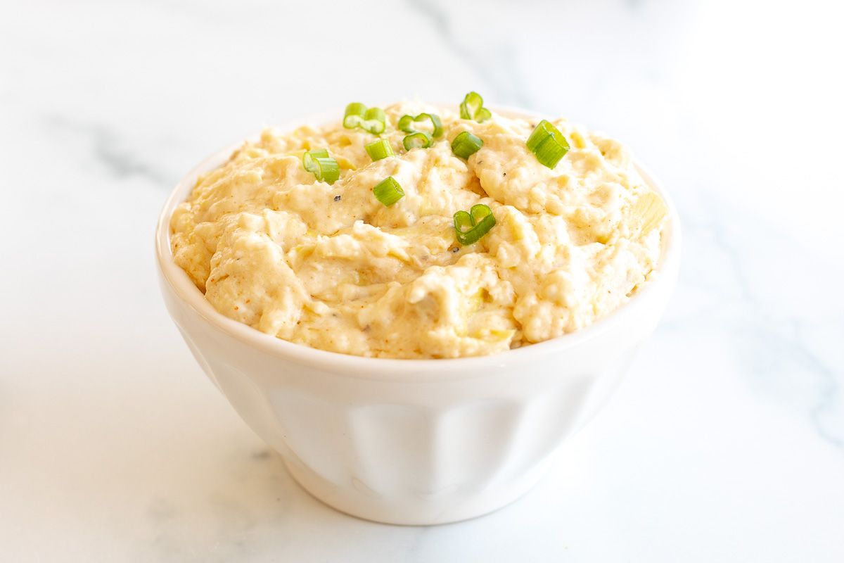 A white bowl full of a artichoke dip recipe