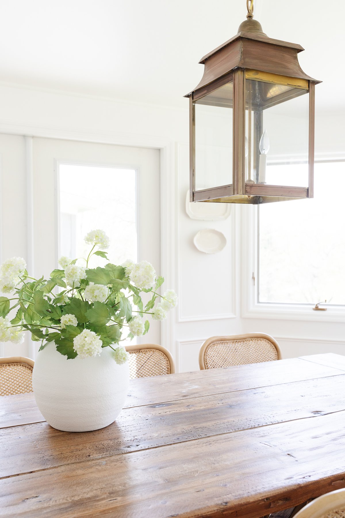 A Restoration Hardware dining table with rattan chairs. 